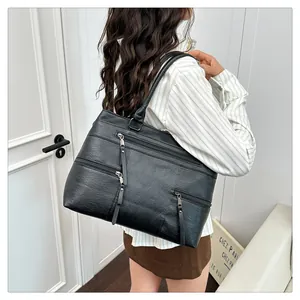 Detail showing high-capacity black shoulder bag with triple front zipper pockets for daily use