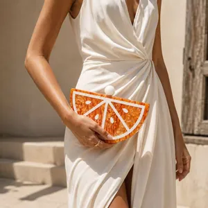 Detail of a bright orange acrylic fruit slice evening bag with marble texture clasp