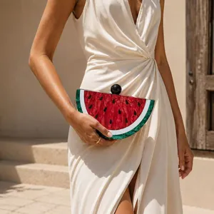 Detail of watermelon acrylic clutch with marble texture held by a model in dress