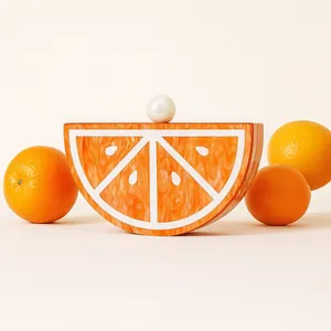 Detail of an orange slice acrylic clutch with marble texture and pearl clasp closure