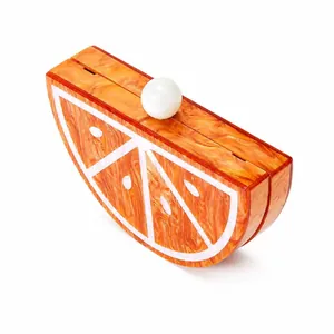 Macro detail of orange slice acrylic clutch featuring marble texture and pearl clasp