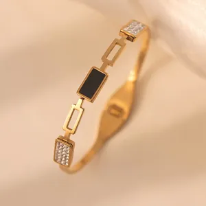 Detail of 18k gold plated titanium steel bracelet with black enamel and zircon inlay