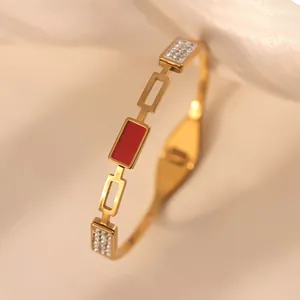 Detailed view of 18k gold plated bangle with red enamel inlay and cubic zirconia stones