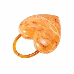 Macro detail of the amber-patterned heart-shaped acrylic handbag with round handle