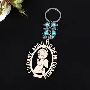 Detail of wooden angel keychain with blue beads and Spanish engraving on black background