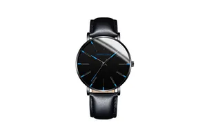 Macro detail of black minimalist watch dial with vibrant blue markers and leather strap