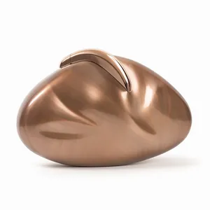 Macro shot of bronze textured acrylic evening bag with organic pebble-shaped hard shell