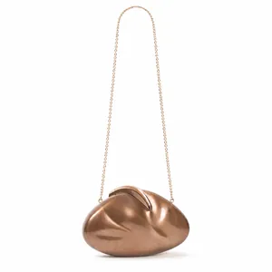 Macro shot of rose gold pebble-shaped evening clutch with brushed metal texture and chain