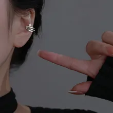 Detail of silver wavy ear cuff wrap with geometric accent on model in profile view