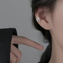 Detail of silver double star non-pierced ear cuff with sparkling texture on ear
