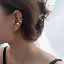 Close-up of three-piece silver ear cuff set including rhinestone and polished metal bands