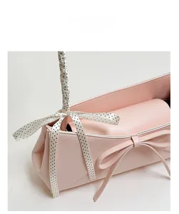 Détail du sac rose avec nœud surdimensionné et ruban à pois sur la poignée