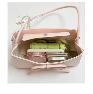 Détail du sac à main en cuir rose montrant sa grande capacité pour les cosmétiques