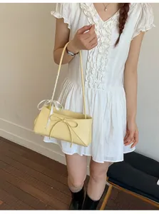 Détail du sac à main en cuir PU jaune clair avec noeud élégant et ruban à pois soyeux