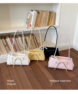 Détail de quatre sacs cabas en similicuir colorés avec un grand nœud décoratif devant