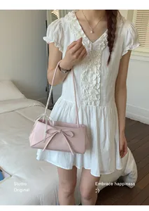 Gros plan sur le sac rose avec nœud 3D et bandoulière fine pour femme