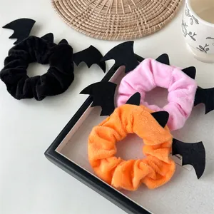 Detailed close-up of colorful plush Halloween scrunchies with black bat wing decorations