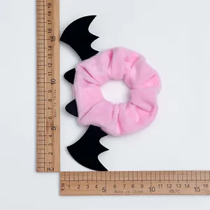 Detailed view of pink velvet bat ear scrunchie showing size measurement with rulers