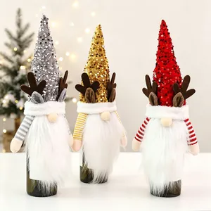 Three sequined gnome wine bottle covers with reindeer antlers for Christmas table decor