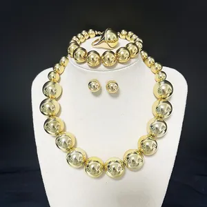 Detail of high-polished gold sphere jewelry set with necklace, bracelet, and ring