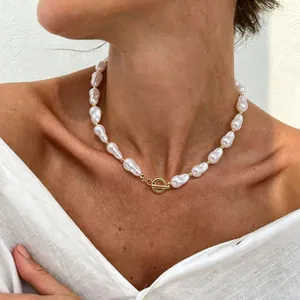Detailed view of baroque pearl necklace with gold OT buckle on model neck