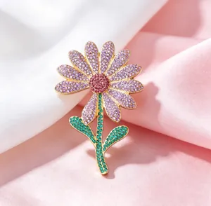 Close-up of luxury daisy brooch with purple and green rhinestones on satin fabric
