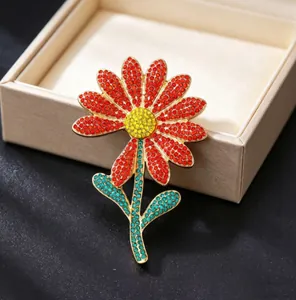 Detailed macro view of a luxury daisy brooch with vibrant red petals and sparkling crystals
