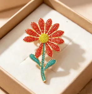 Macro shot of colorful rhinestone daisy brooch with intricate micro-pave craft in a gift box