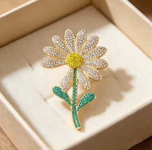Close-up of a sparkling crystal daisy brooch in a premium jewelry gift box
