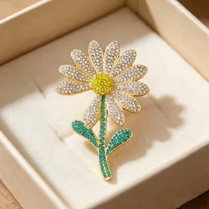 Luxury daisy flower brooch pin with sparkling white and yellow crystals in golden finish