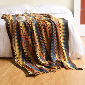 Detail of bohemian knitted blanket with colorful zigzag patterns and tassel fringe