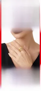 Detail of layered gold-plated 925 silver cross ring featuring moissanite on model hand