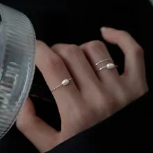Detail of elegant silver ring with single pearl shown on hand for a minimalist aesthetic