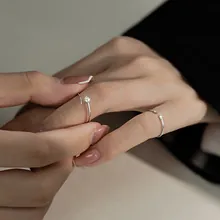 Close-up of minimalist silver adjustable rings with single zircon on hand