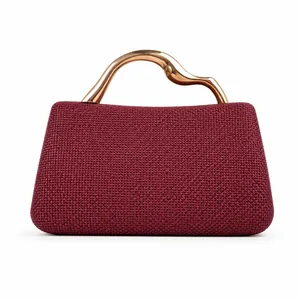 Detail of dark red woven clutch featuring an artistic wavy gold metal handle