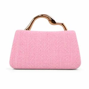 Detail of light pink woven handbag with stylish rose gold wavy metal handle for evening