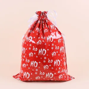 Detail of red Christmas drawstring gift bag with white snowflakes and HO HO HO text design