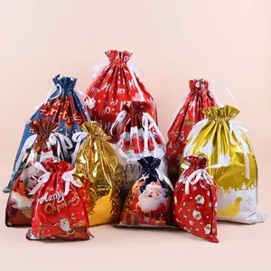 Close-up of assorted Christmas drawstring gift bags with Santa and reindeer patterns