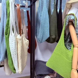 Detail of bohemian hollow knit tote bags in various colors on a retail display rack