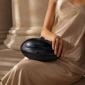 Gros plan d'une pochette de soirée en acrylique marbré avec fermoir argenté chic
