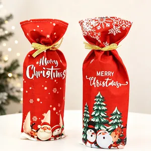 Detail of red Christmas wine bottle gift bags with gold ribbons and festive prints