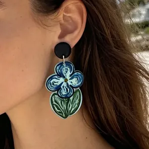 Orecchini artistici in stile Van Gogh con fiori blu indossati per un look dolce ed elegante