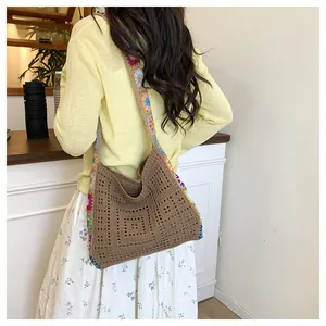 Detail of crochet tote bag with colorful floral strap and dark brown hollow weave