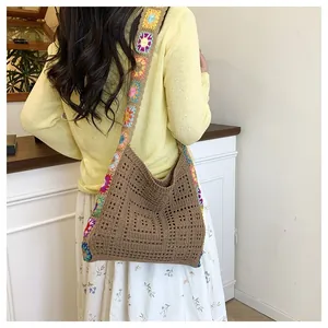 Detail of crochet tote bag featuring brown hollow weave and colorful floral patterns