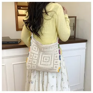 Detailed back view of a beige hollow crochet tote bag with colorful floral embroidery
