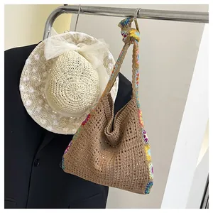 Detail of hollow woven tote bag featuring colorful crochet floral patterns on strap