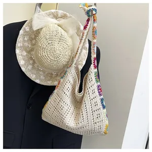 Close-up of hollow knit texture and colorful crochet floral details on a shoulder bag