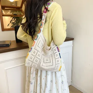 Hollow out knit shoulder bag with colorful floral strap for a summer bohemian style look