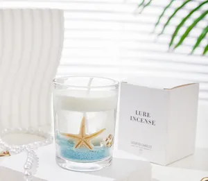 Detail of ocean-themed jelly candle with real starfish, shells and blue sand in glass