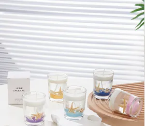 Detail of four ocean jelly candles with sea shells in a premium minimalist gift box